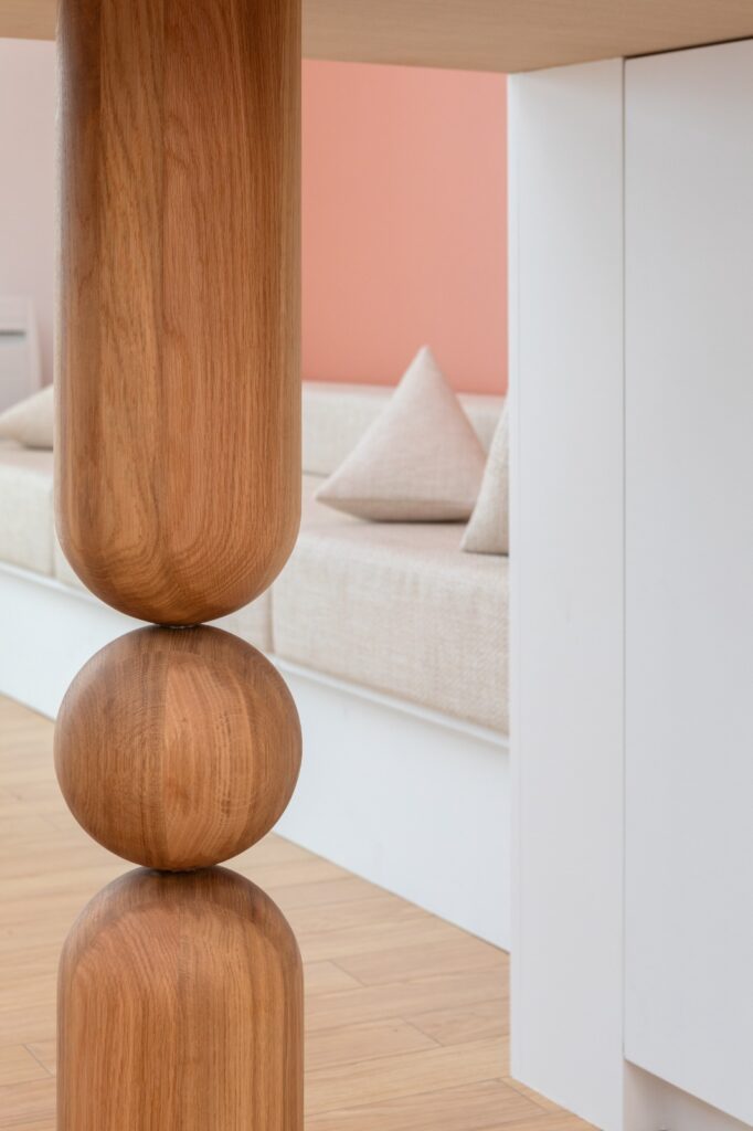 Détail du piètement sculpté d’une table de réunion en bois sur mesure