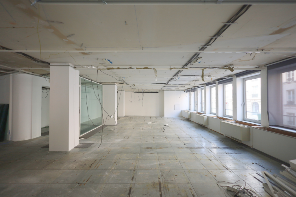 Plateau de bureaux après curage partiel avec réseaux apparents